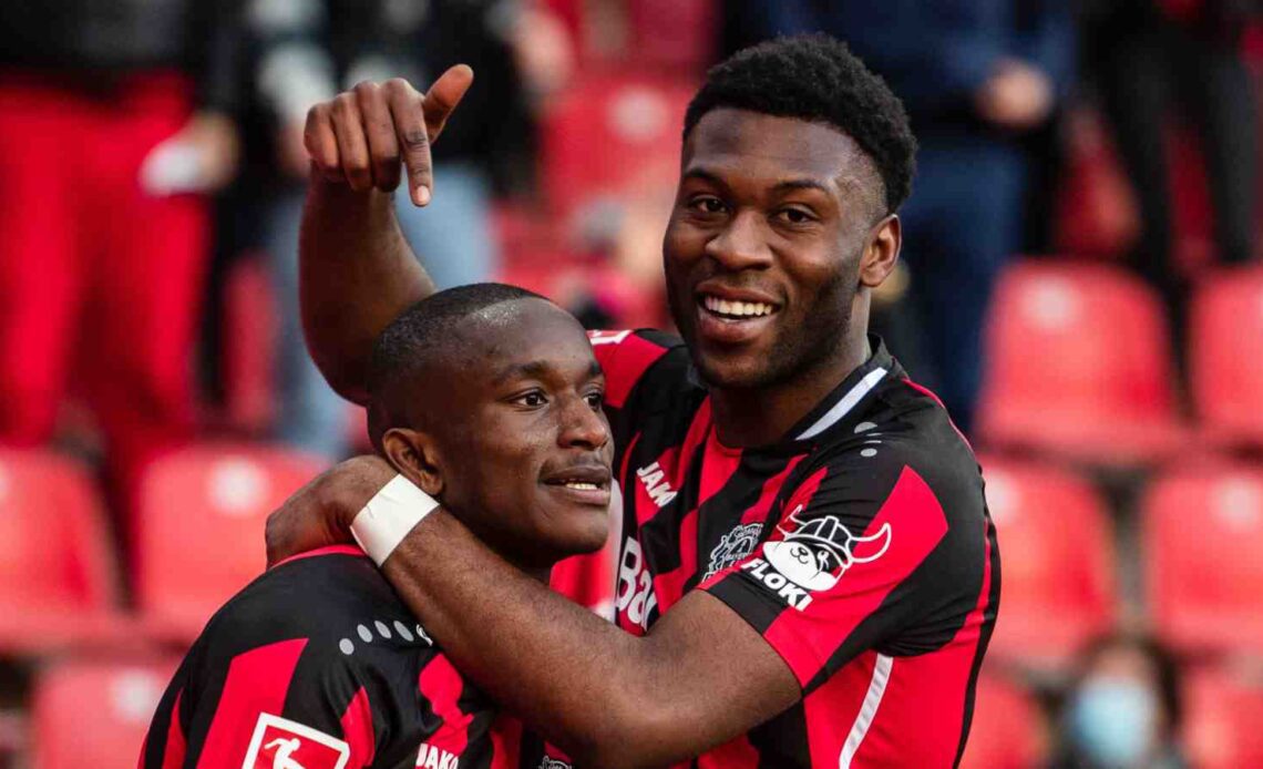 Timothy Fosu-Mensah pointing to Bayer Leverkusen teammate Moussa Diaby