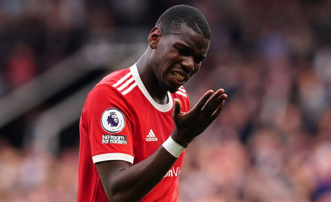 Man Utd midfielder Paul Pogba grimaces and looks at his hand