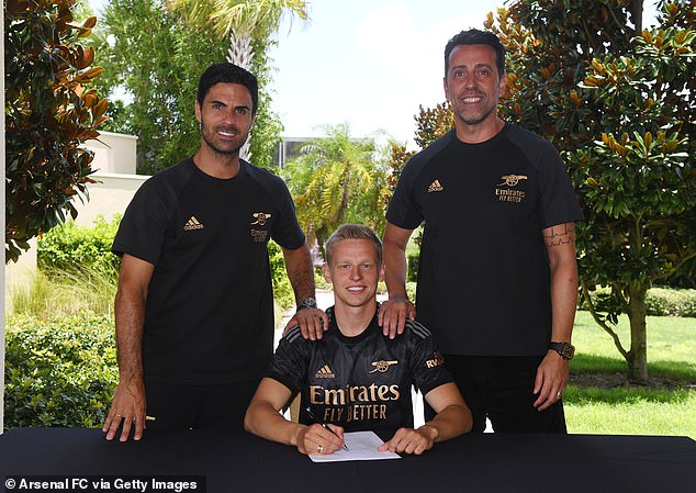 Zinchenko signs his long term deal with the club alongside Mikel Arteta (left) and Edu