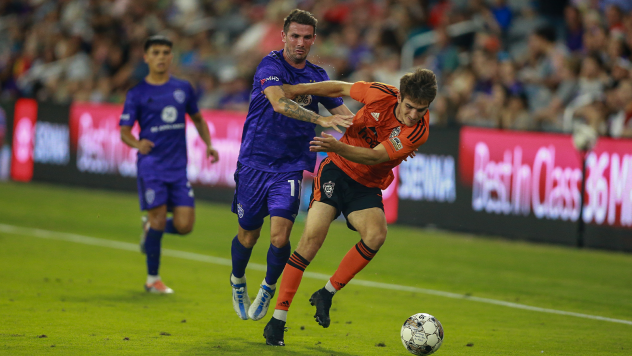 Louisville City FC midfielder Niall McCabe (center) fights for the ball