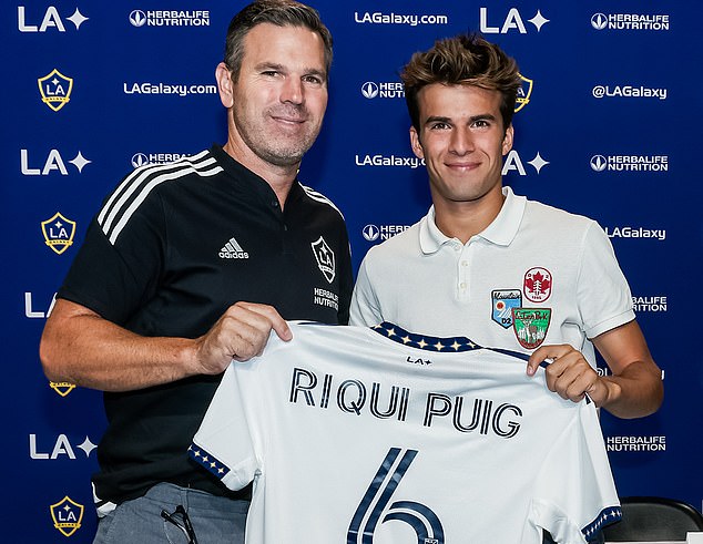 Puig stands next to LA Galaxy head coach Greg Vanney while his jersey is unveiled to media