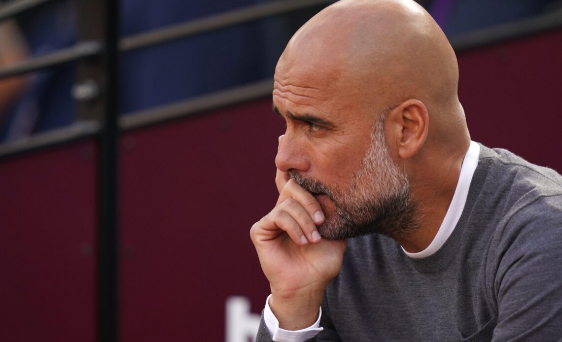 Pep Guardiola sat on the bench before a game