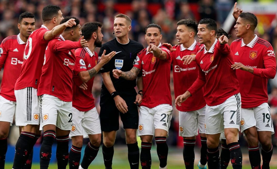 Man Utd players surround the referee