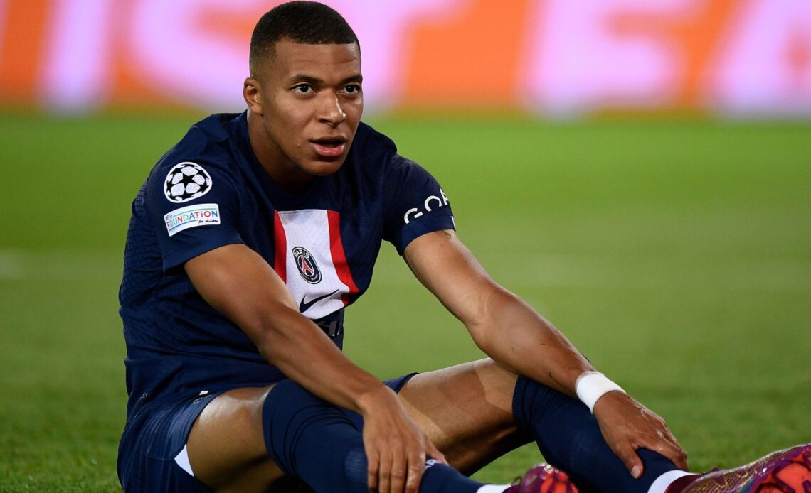 Kylian Mbappe sits on the ground