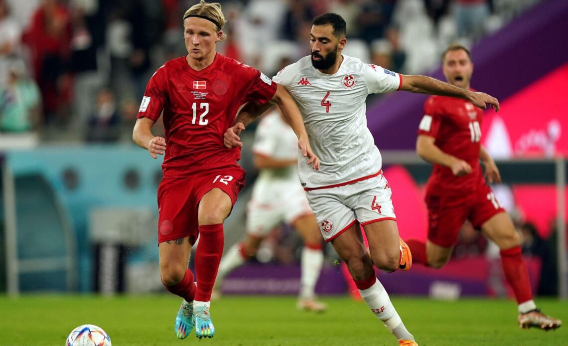 Denmark attacker Kasper Dolberg and Tunisia's Yassine Meriah tussle for the ball