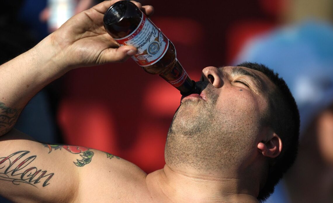 A fan drinks a Budweiser in the stands at a World Cup match