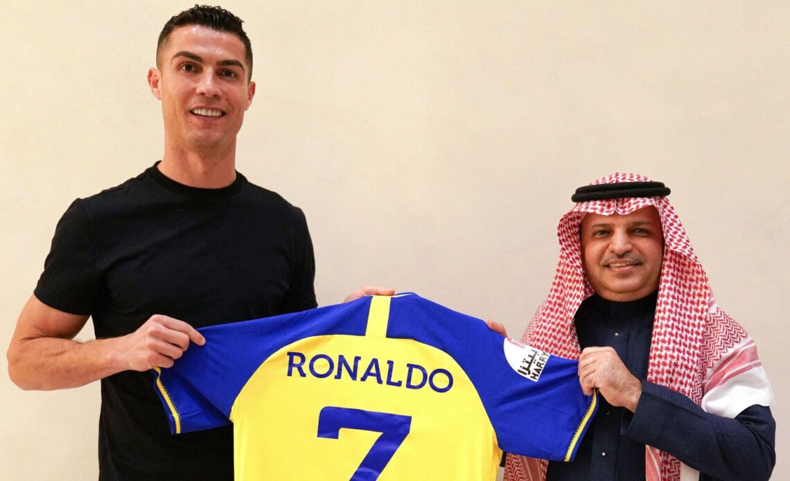 Cristiano Ronaldo holds up a shirt