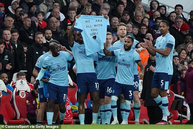 Brentford players hold up a shirt honouring team-mate Sergi Canos' late mother who passed away earlier in the week