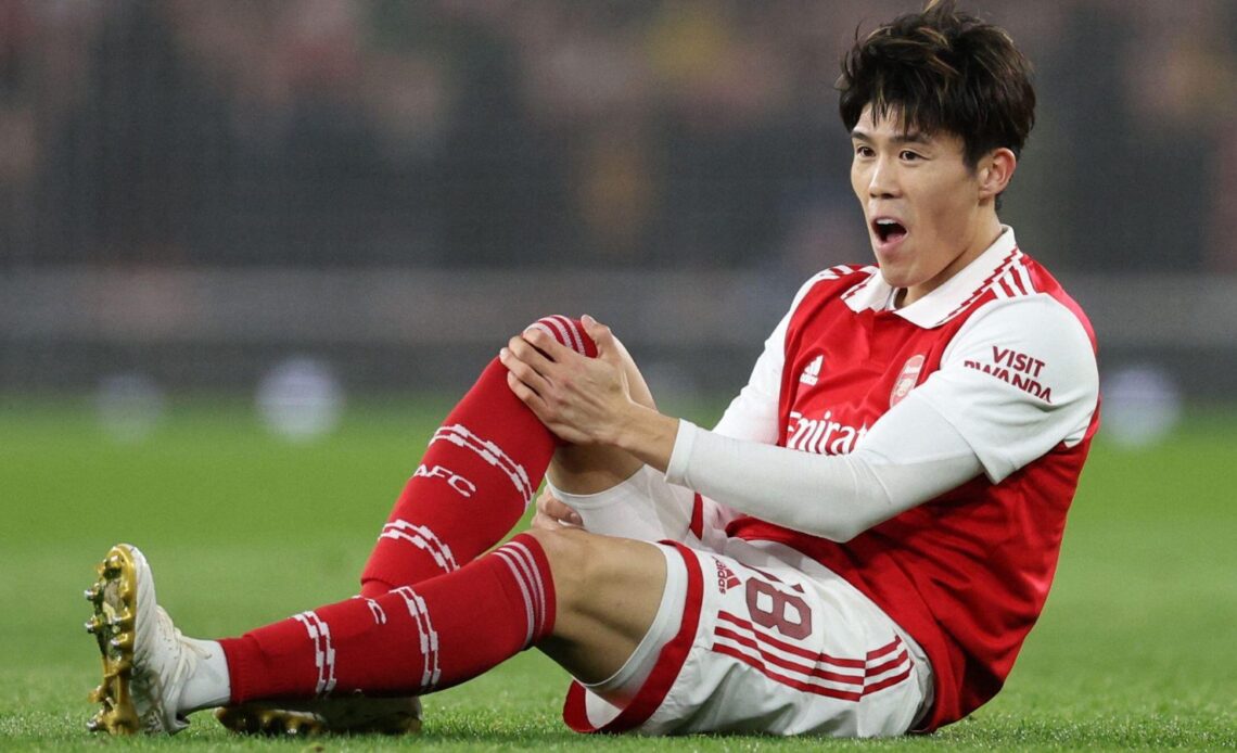 Arsenal defender Takehiro Tomiyasu holds his knee in pain