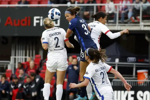 Washington Spirit forward Ashley Hatch (center) goes high for the ball