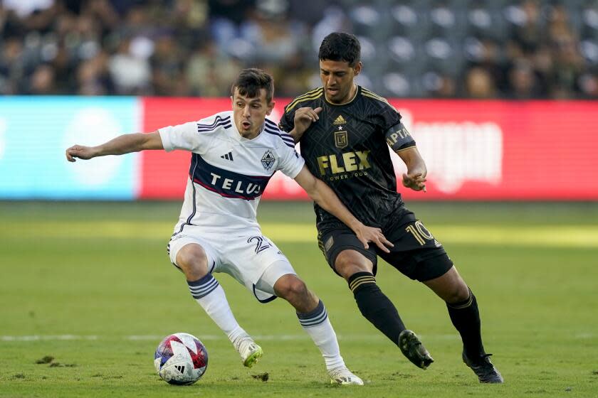 Vancouver Whitecaps midfielder Andrés Cubas, left, and Los Angeles FC forward Carlos Vela vie for the ball during the first half of an MLS playoff soccer match Saturday, Oct. 28, 2023, in Los Angeles. (AP Photo/Ryan Sun)