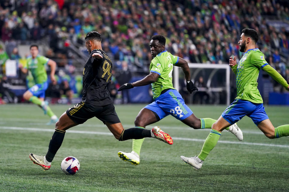 Los Angeles FC forward Denis Bouanga (99) winds back to score as Seattle Sounders defender Yeimar Gómez (28) and midfielder Alex Roldan, right, look on during the first half of an MLS conference semifinal playoff soccer match Sunday, Nov. 26, 2023, in Seattle. (AP Photo/Lindsey Wasson)