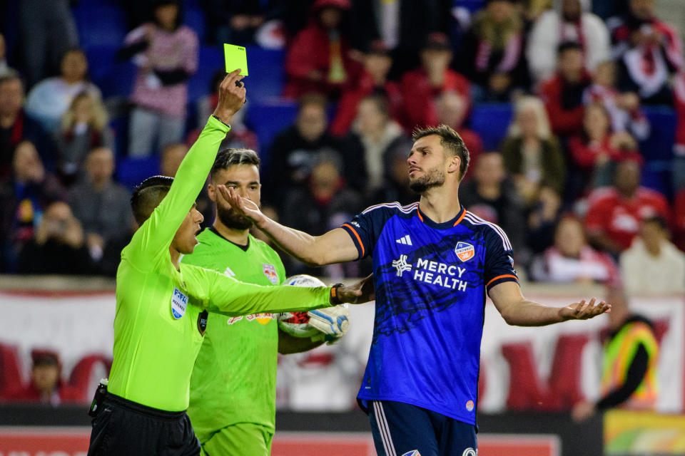 HARRISON, NJ - NOVEMBER 4: Referee Victor Rivas gives a yellow card to Matt Miazga #21 of FC Cincinnati during the penalty kick shootout during the Audi 2023 MLS Cup Playoffs Round One game between FC Cincinnati and New York Red Bulls at Red Bull Arena on November 4, 2023 in Harrison, New Jersey. (Photo by Howard Smith/ISI Photos/Getty Images)