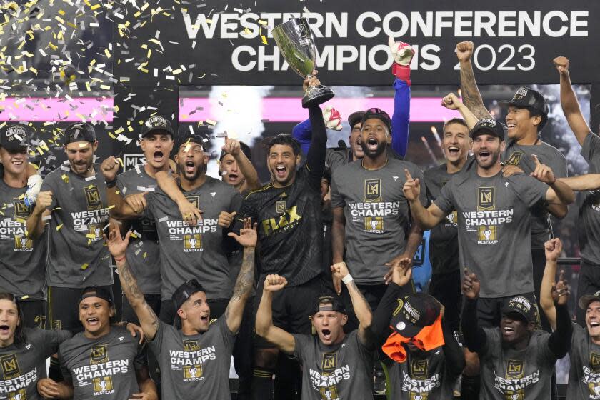 LAFC forward Carlos Vela, center, holds the MLS Western Conference trophy after LAFC's 2-0 victory at BMO Stadium.