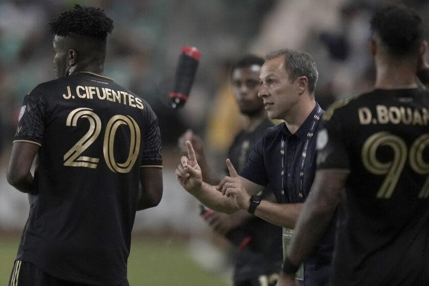 LAFC coach Steve Cherundolo talks with Jose Cifuentes on the sideline during a match