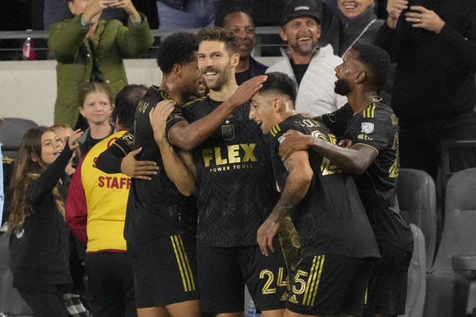 Los Angeles FC midfielder Ryan Hollingshead, center, celebrates his goal with teammates during the first half in the MLS playoff Western Conference final soccer match against Houston Dynamo, Saturday, Dec. 2, 2023, in Los Angeles. (AP Photo/Marcio Jose Sanchez)