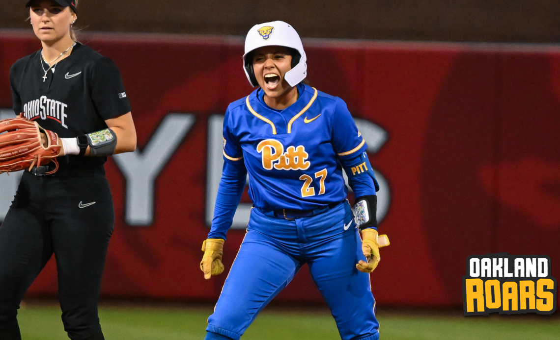 A PItt softball player yells in celebration from second base