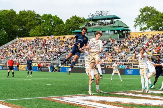 Rhode Island FC and Louisville City FC battle for a ball in the air