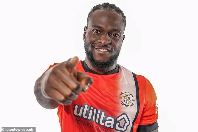 Victor Moses pictured posing in Luton's home shirt after joining the club on a free transfer