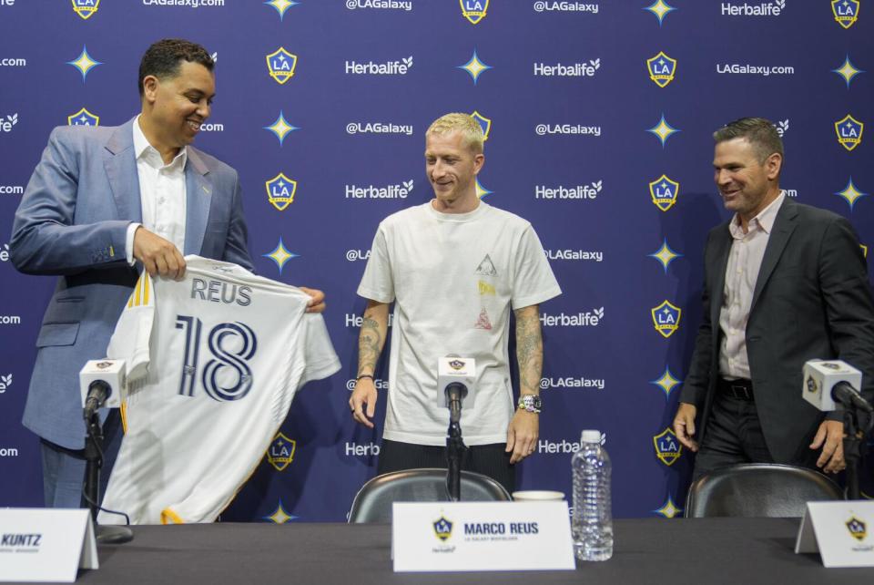 Galaxy general manager Will Kuntz and coach Greg Vanney give German midfielder Marco Reus with his MLS soccer jersey