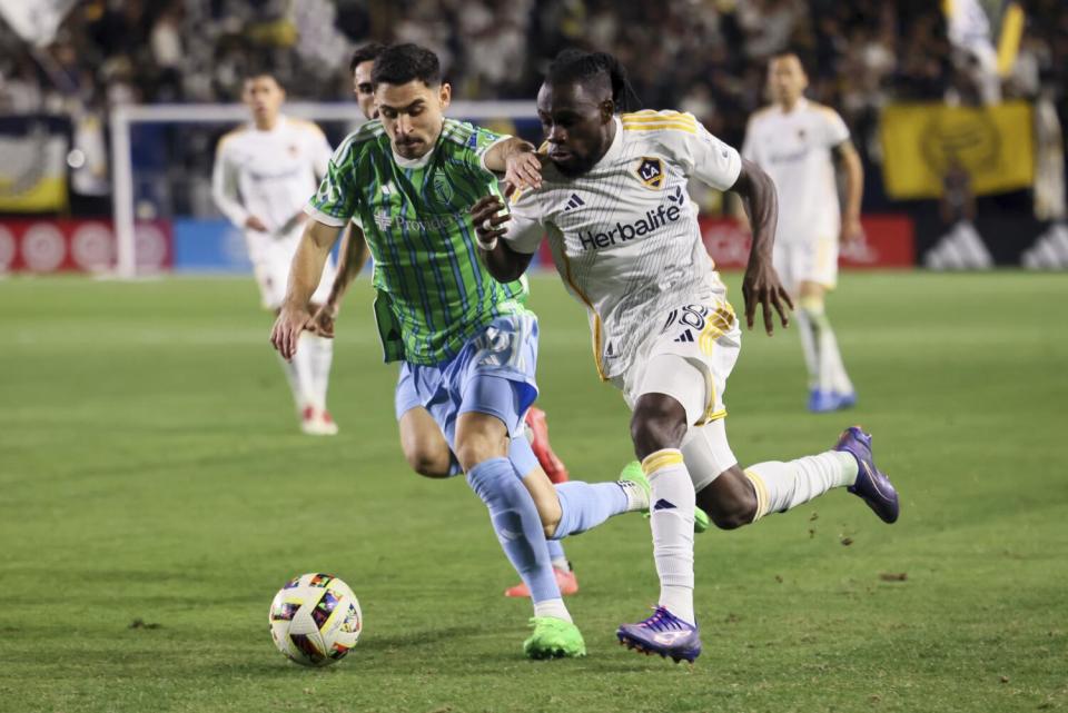 Galaxy forward Joseph Paintsil is defended by Sounders midfielder Alex Roldan during the MLS Western Conference final